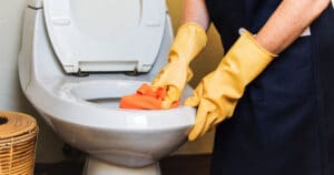 Employé de nos services d'entretien ménager commercial nettoyant les toilettes